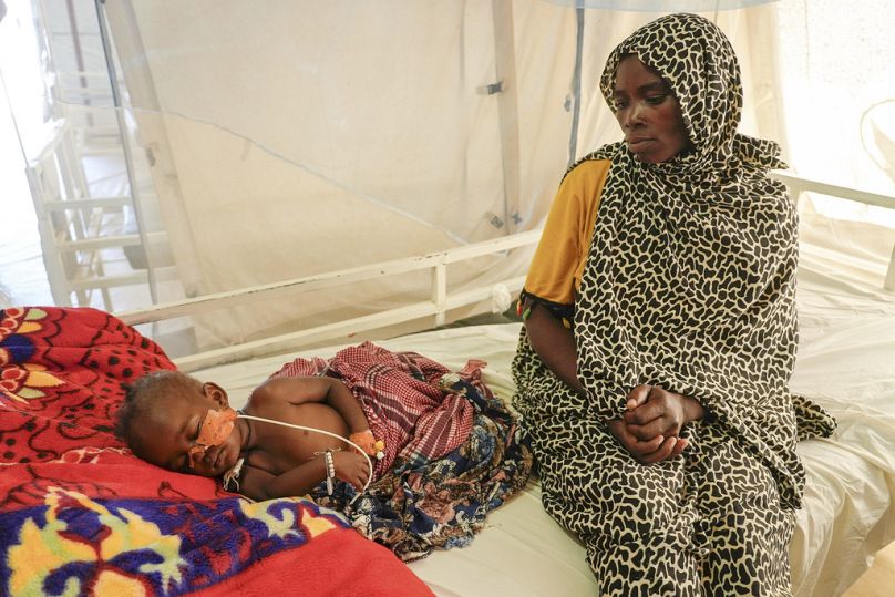 خديجة عمر آدم تجلس إلى جانب طفلها المريض في عيادة تديرها منظمة أطباء بلا حدود في موقع أبوتنغي للنازحين بالقرب من عكا، تشاد، الجمعة، 4 أكتوبر/تشرين الأول. 2024. 