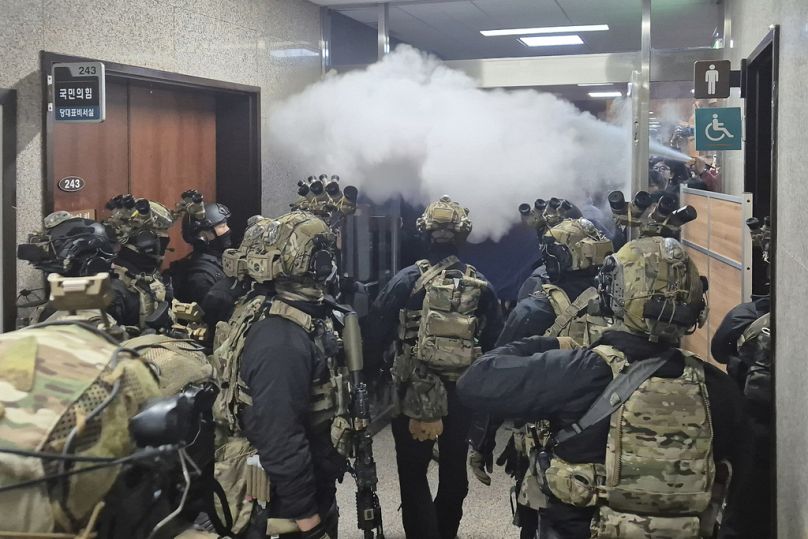 National Assembly staff spray fire extinguishers to block soldiers entering the main hall of the National Assembly in Seoul, South Korea, Wednesday, Dec. 4, 2024.