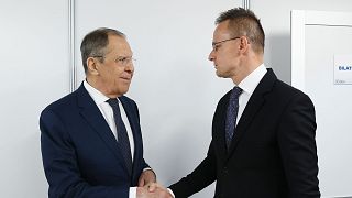 Russian Foreign Minister Sergey Lavrov shakes hands with Hungarian Minister of Foreign Affairs and Trade Peter Szijjarto on Thursday, 30 November 2023.