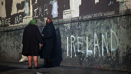 FILE: Women chat on a pavement against a background of political slogans written on a wall in Belfast, Northern Ireland in 1972. 