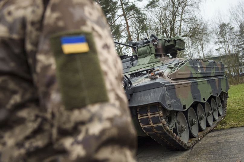 A Ukrainian soldier is standing in front of a Marder infantry fighting vehicle at the German forces Bundeswehr training area in Munster, Germany, on Feb. 20, 2023.