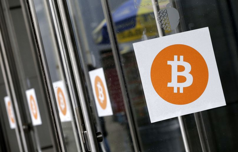 شعارات بيتكوين معروضة في مؤتمر ومعرض إنسايد بيتكوين التجاري في 7 أبريل 2014 في نيويورك. تجاوزت عملة البيتكوين حاجز الـ 100 ألف دولار. 