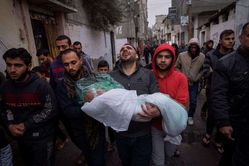 محمد شومان يحمل جثمان ابنته ماسة، التي قُتلت في قصف إسرائيلي على قطاع غزة، خلال جنازتها في رفح، جنوب قطاع غزة، 17 يناير/كانون الثاني 2024
