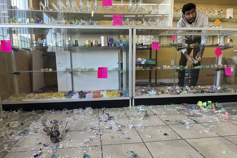 Hasan Raza cleans up in the aftermath of an earthquake inside E&J Liquors in Rio Dell, 5 December, 2024