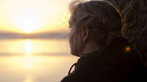 A young woman looks out over the horizon.