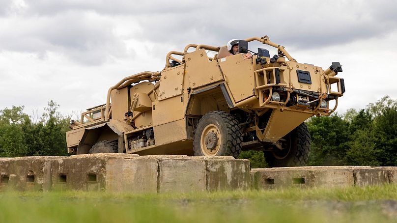 A soldier tests the electrical hybrid system of a Jackal vehicle, which has increased vehicle torque and climbing capabilities.