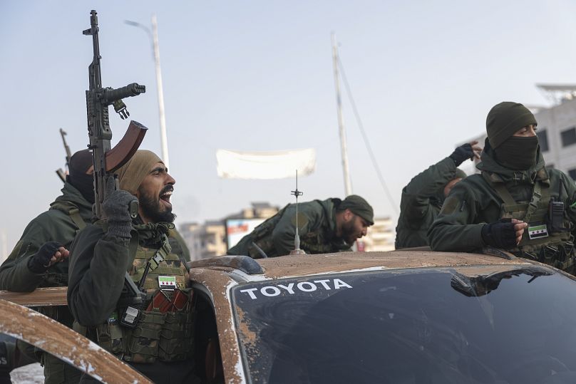 Syrian opposition fighters ride along the streets in the aftermath of the opposition's takeover of Hama, 6 December, 2024