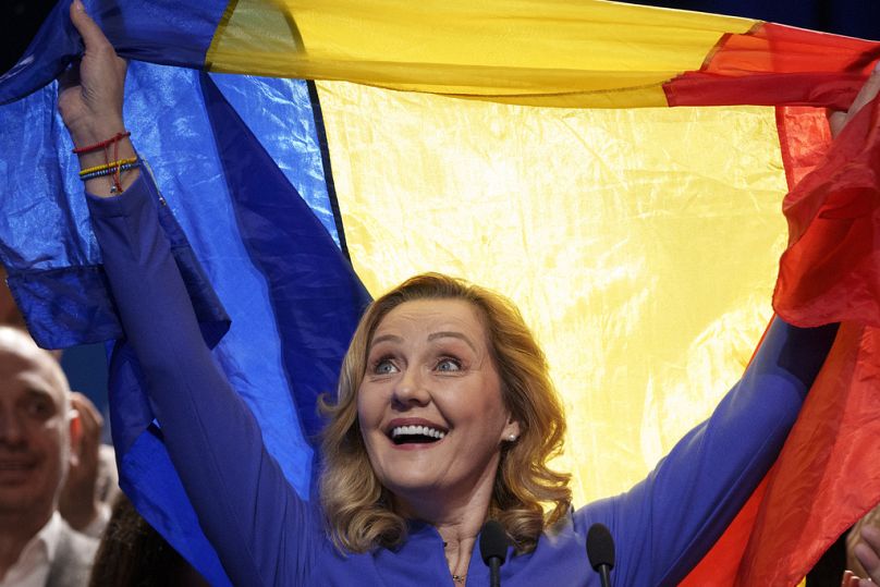 Elena Lasconi, candidata del partido Unión Salvar Rumania (USR) en las elecciones presidenciales del país, sostiene la bandera de Rumania al final de una reunión