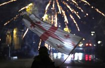 A demonstrator waves a Georgian flag during a protest in Tbilisi, 7 December, 2024