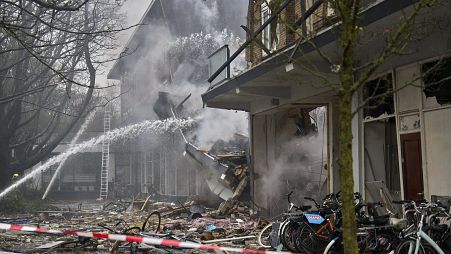 Firefighters hose down the site of an explosion which destroyed several apartments in The Hague, 7 December, 2024