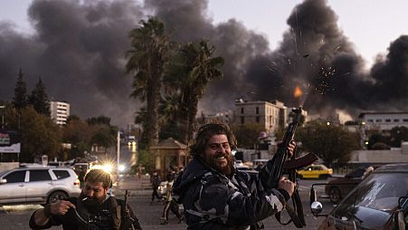 Personas disparan al aire mientras celebran la caída del gobierno sirio en Damasco, Siria, domingo 8 de diciembre de 2024.
