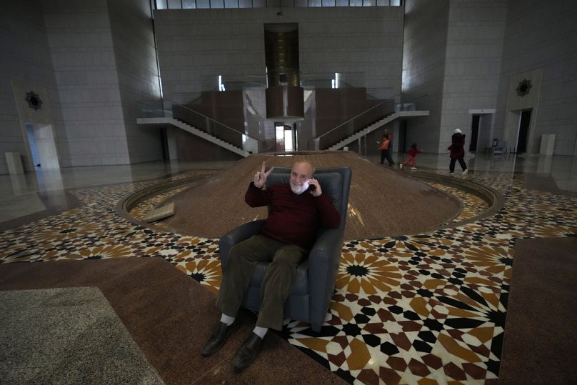 Un Syrien assis sur une chaise à l'intérieur du palais présidentiel  à Damas, en Syrie, le dimanche 8 décembre 2024.