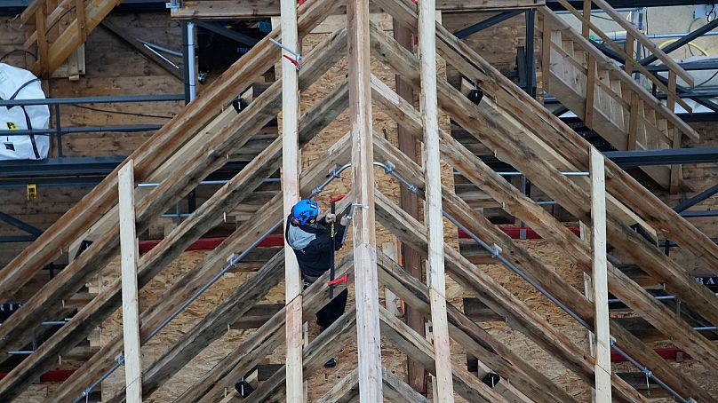 A carpenter works on the roof restoration of Notre-Dame, Paris, using oak trees planted by jay birds.