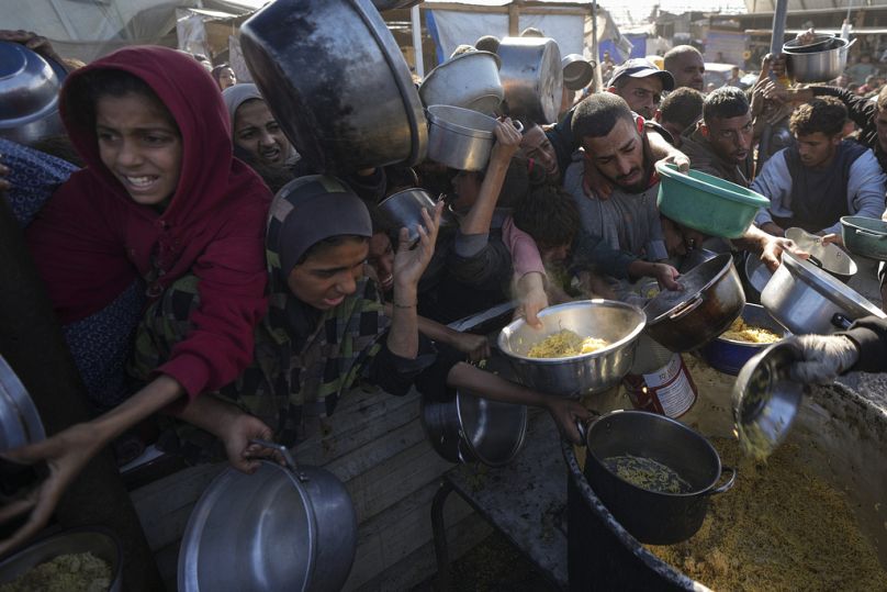 فلسطينيون يكافحون للوصول إلى الطعام بمركز في خان يونس، قطاع غزة، الجمعة، 6 ديسمبر، 2024.