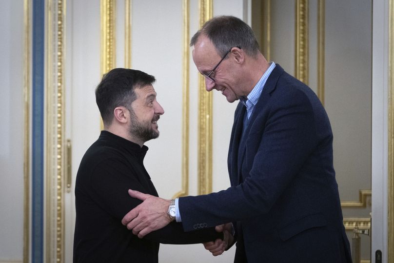 الرئيس الأوكراني فولوديمير زيلينسكي ورئيس الحزب الديمقراطي المسيحي الألماني فريدريش ميرتس يتصافحان في كييف.
