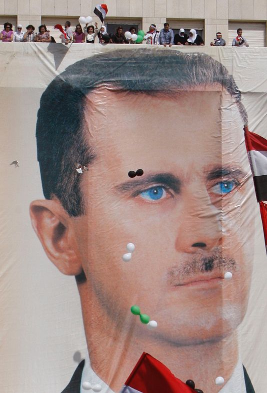 Aszad hívei az elnök óriási arcképe felett Damaszkuszban, 2011 októberében