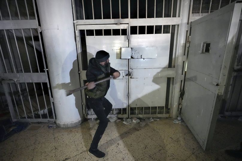 Imagen de un hombre rompiendo la cerradura de una celda en la prisión militar de Saidnaya, al norte de Damasco, Siria, el lunes 9 de diciembre de 2024.