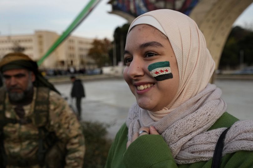 Une Syrienne avec le drapeau révolutionnaire peint sur son visage, Damas, Syrie, le 9 décembre 2024.