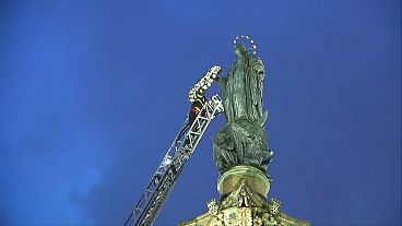 Firefighter placing a wreath of flowers on the arm of the statue of the Virgin Mary in Rome, Italy, 08.12.2024