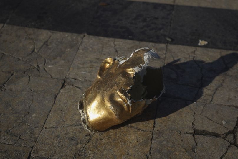 A broken bust of the former Syrian leader Hafez al-Assad, father of Bashar al-Assad, lies on the ground destroyed by opposition fighters in Aleppo, 30 November 2024