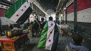 Sostenitori dell'opposizione portano bandiere dell'opposizione lungo il mercato di Al-Hamidiyeh all'interno della vecchia città murata di Damasco, Siria, martedì 10 dicembre 2024.