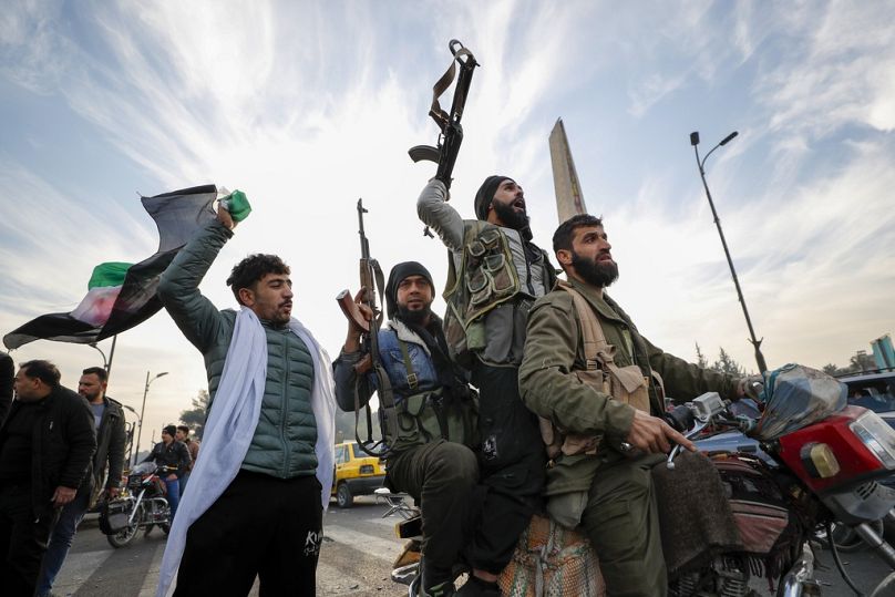 Syrian opposition fighters celebrate after the Syrian government collapsed in Damascus, Syria, Sunday, Dec. 8, 2024