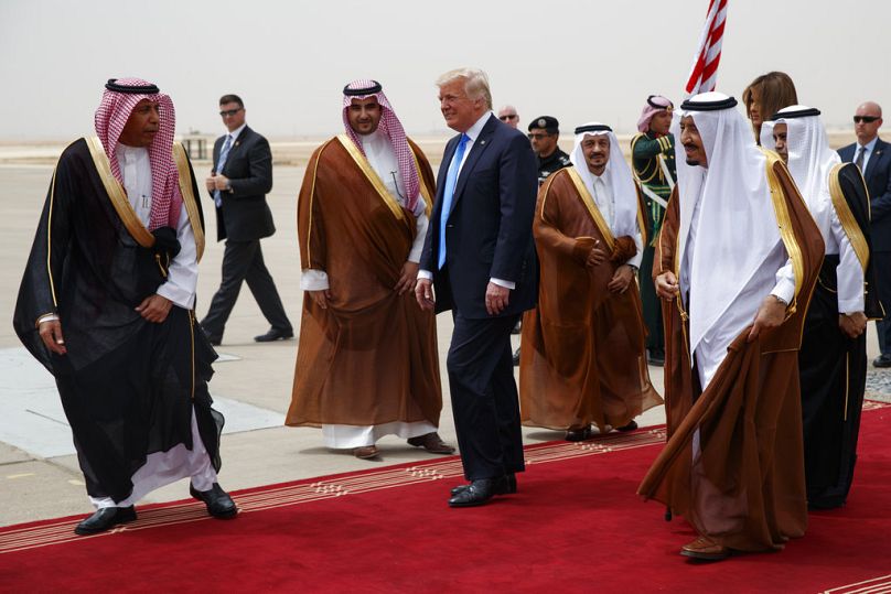 الرئيس دونالد ترامب يسير مع الملك السعودي سلمان خلال حفل استقبال في الصالة الملكية بمطار الملك خالد الدولي، السبت 20 مايو 2017، في الرياض. 