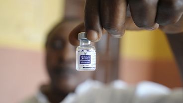 A health worker shows a bottle of the malaria vaccine before administering it to a child in Nigeria in December 2024.