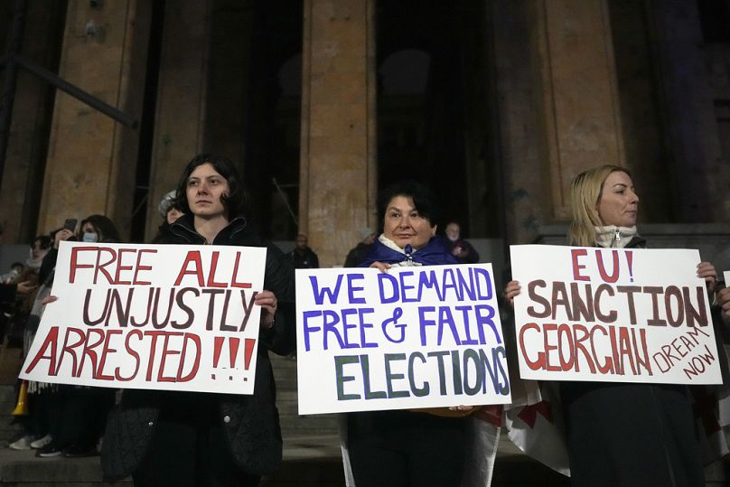 Manifestantes protestam em frente ao parlamento contra a decisão do governo de suspender as negociações de adesão à UE em Tbilisi, Geórgia, no sábado, 7 de dezembro de 2024.