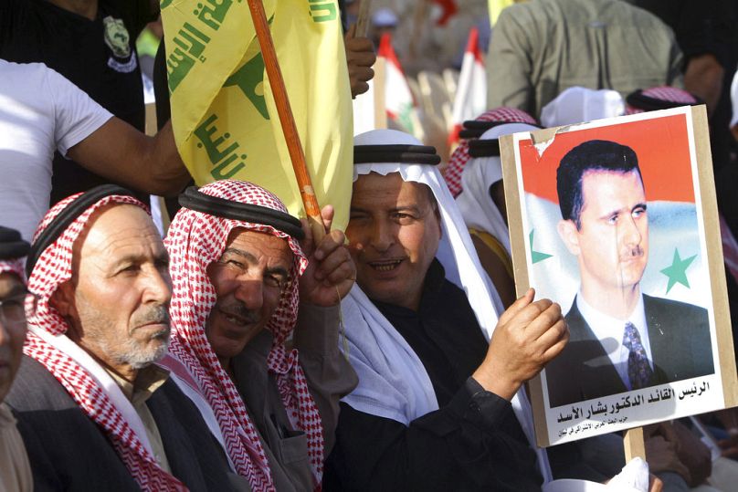 مؤيدو حزب الله يحملون صورة للرئيس السوري بشار الأسد وهم يستمعون إلى زعيم حزب الله حسن نصر الله، في قرية مارون الراس جنوب لبنان 2018