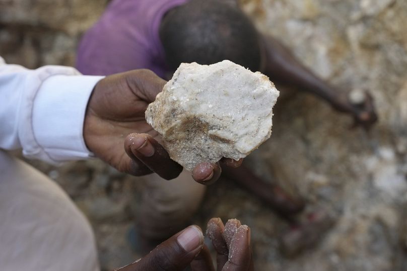 A man shows lithium stone from an illegal mining site in Paseli, north central Nigeria, Tuesday, Nov 5, 2024. (AP Photo/Sunday Alamba)