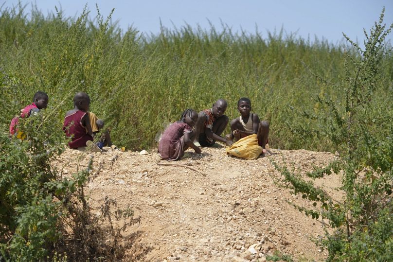 Juliet Samaniya, 6, chips at a rock with other children at an illegal lithium mining site in Paseli, Nigeria, Tuesday, Nov 5, 2024.