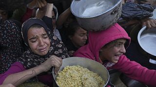 Bambine cercano cibo in un centro di distribuzione di aiuti a Khan Younis, nella Striscia di Gaza