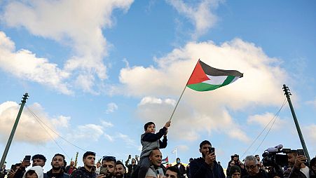 People attend a rally celebrating the fall of Syrian President Bashar Assad's government, at central Syntagma square, in Athens, Greece, Sunday, Dec. 8, 2024. 