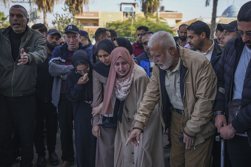 Palestinians mourn over the bodies of civilian victims of an overnight Israeli air strike on the Nuseirat refugee camp, 12 December, 2024