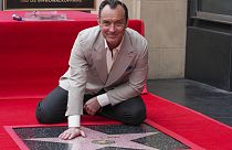 Jude Law poses with his new star at a ceremony honoring him
