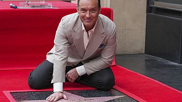 Jude Law poses with his new star at a ceremony honoring him