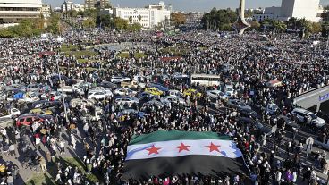 Syrians gather during a celebratory demonstration following the first Friday prayers since Bashar al-Assad's ouster in Damascus, 13 December, 2024