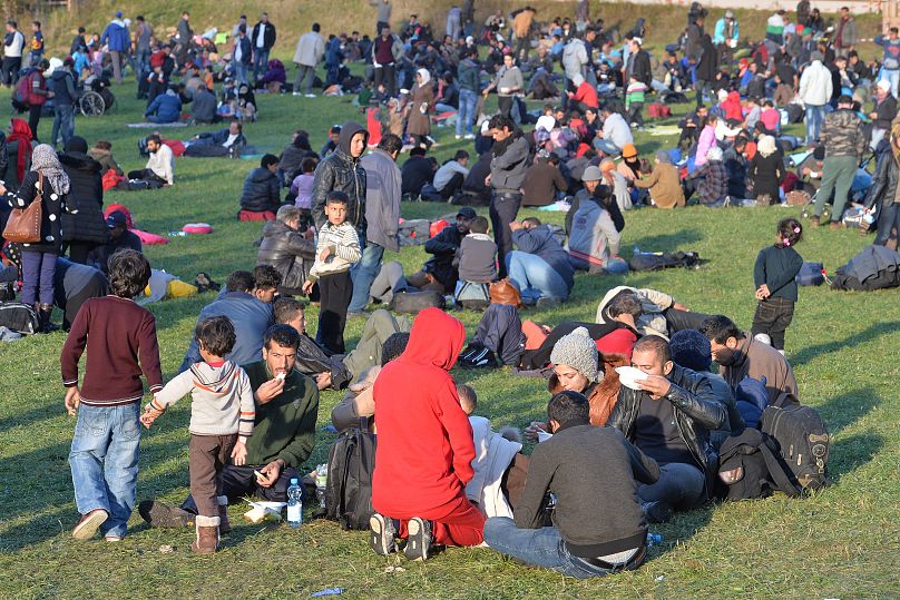 Migrants rest on a meadow at the border between Austria and Germany near Kollerschlag, 28 October, 2015