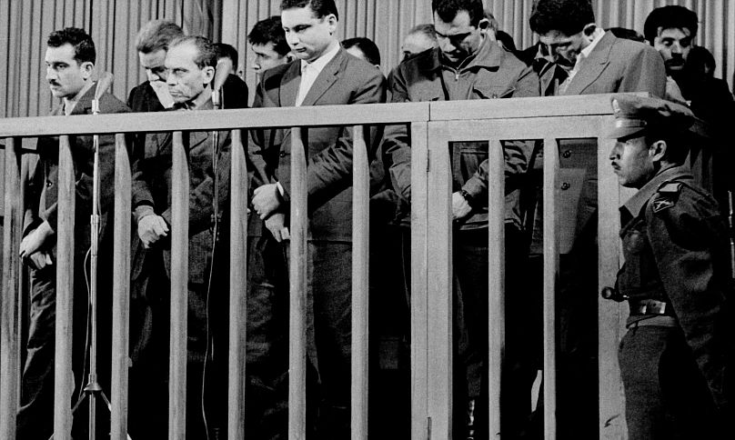 إيلي كوهين، على أقصى اليسار، يستمع أثناء الحكم عليه بالإعدام من قبل محكمة عسكرية خاصة في دمشق، سوريا، 8 مايو/أيار 1965