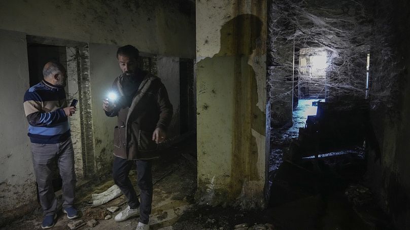 Két férfi zseblámpájával kutatja át a hírhedt Szednaja katonai börtön folyosóját