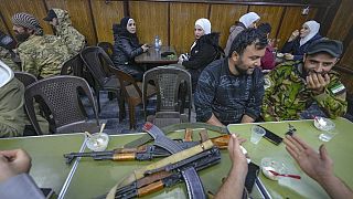 FILE - Opposition fighters sit in a restaurant at the Al-Hamidiyeh market inside the old walled city of Damascus, Syria, Tuesday, Dec. 10, 2024. (AP Photo/Hussein Malla)