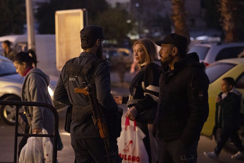 عناصر شرطة من إدلب يقفون أمام مركز للشرطة في حي باب توما في مدينة دمشق القديمة، سوريا، السبت، 14 ديسمبر/كانون الأول 2024