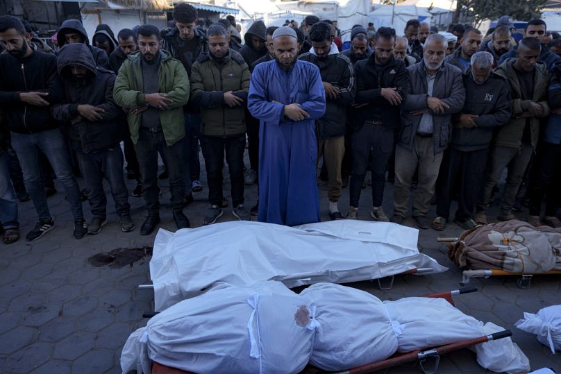 Palestinians pray next to the bodies of their relatives killed in the Israeli bombardment of the Gaza Strip, at a hospital in Deir al-Balah, Sunday, Dec. 15, 2024.