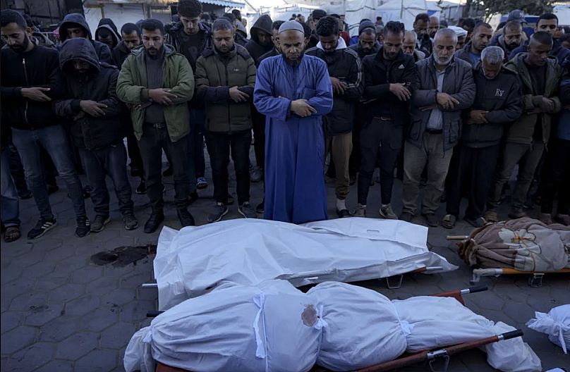 Filistinliler, Deyr El Balah'taki bir hastanede, Gazze Şeridi'ne yönelik İsrail bombardımanında öldürülen yakınlarının cansız bedenlerinin yanında dua ediyor, 15 Aralık 2024.