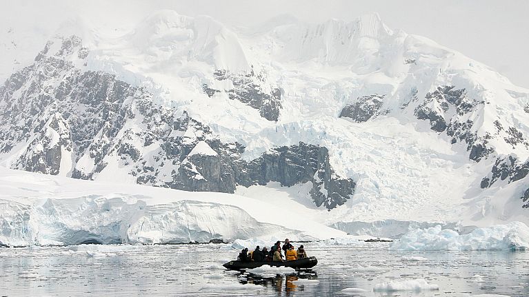 Tourists get close to icebergs and the Antarctic coast during a shirt excursions on a Zodiac boat in Brown Bluff, Antarctica. Tourists get close to icebergs and the Antarctic coast during a shirt excursions on a Zodiac boat in Brown Bluff, Antarctica.