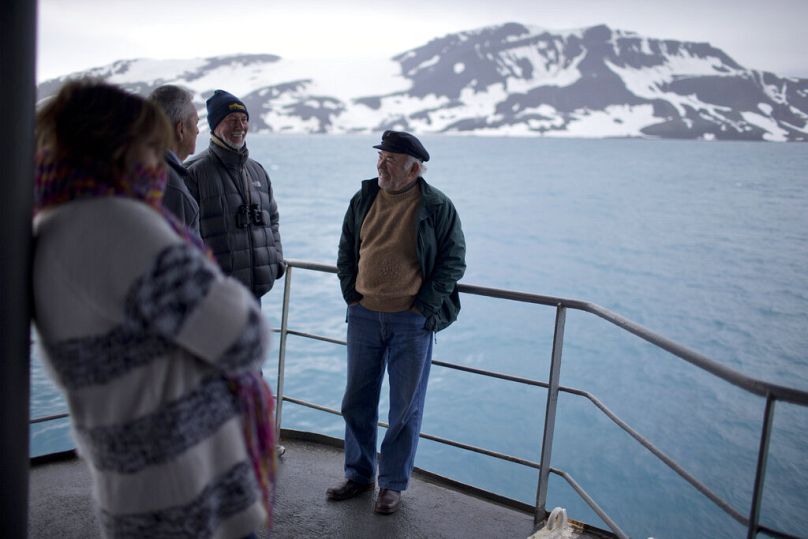 Tourists stand on The Aquiles, a Chilean Navy icebreaker, near Bahia Almirantazgo, Livingston Island, South Shetland Island archipelago, Antarctica. 