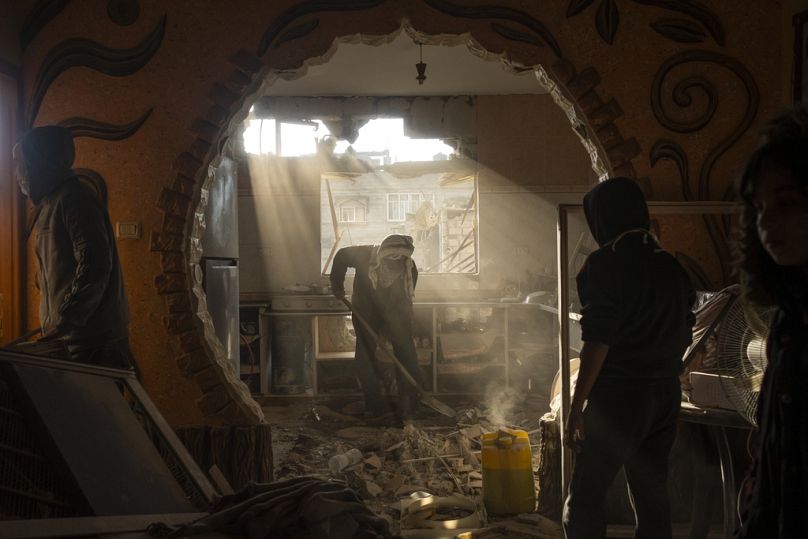 FILE: Palestinians look at their neighbour's damaged house following an Israeli strike in Rafah, southern Gaza Strip, January 2024