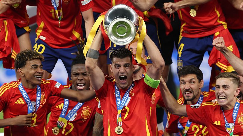 Álvaro Morata magasba emeli az Eb-trófeát spanyol csapattársai gyűrűjében 2024. július 14-én.