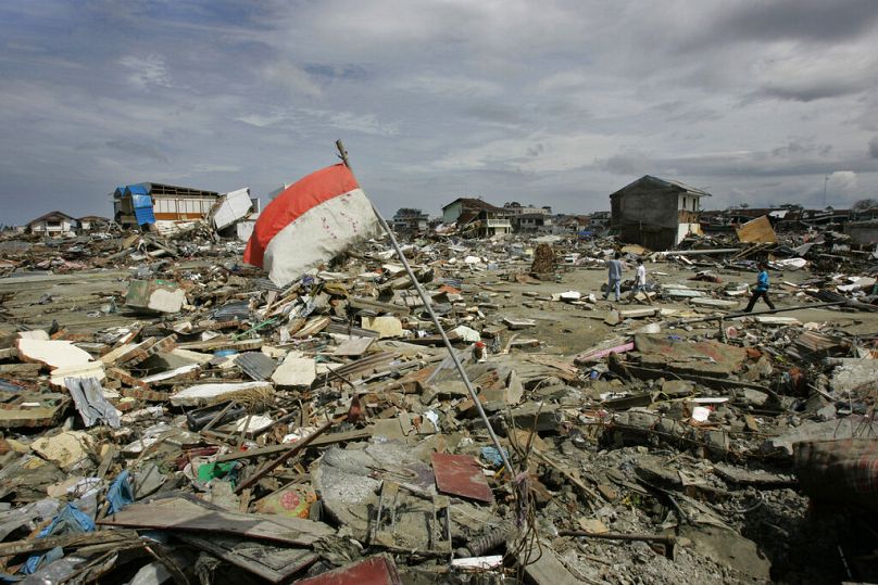 An Indonesian flag flies over the rubble in the center of Banda Aceh, Indonesia, Sunday Jan. 2, 2005.